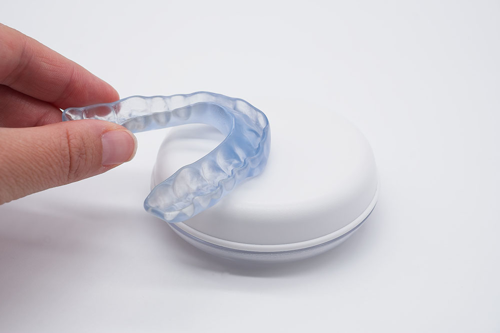Doctor holding transparent dental night guard