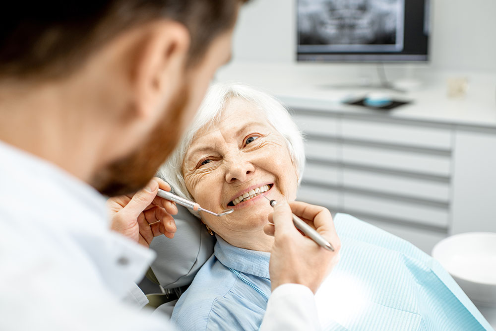 Elderly woman during the medical examination with male dentist in the dental office